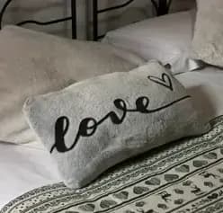 Dettaglio dei cuscini della camera da letto: sopra c'è scritto 'love'