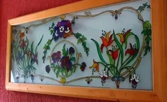 Vetrata decorativa sopra al divano con fiori