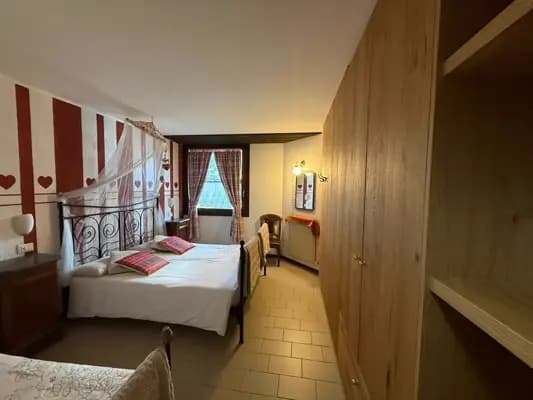Camera da letto: letto matrimoniale con struttura in metallo, grande finestra che rende la stanza luminosa e letto singolo