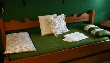 Divano-letto con struttura in legno; fra i dettagli c'è la scritta 'Jolly Residence'