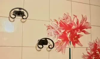 Dettaglio di decoupage in bagno, con dei fiori sul muro