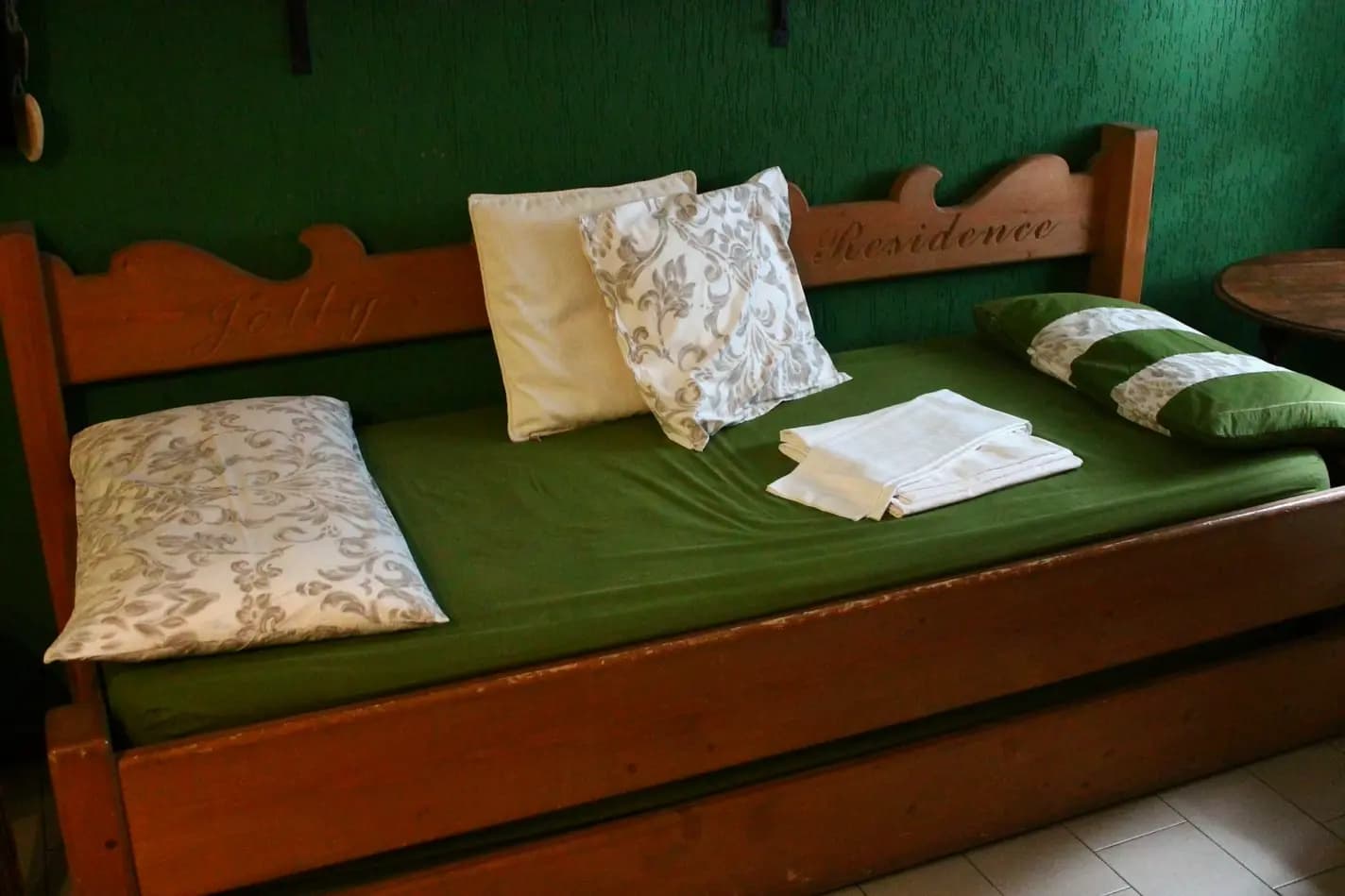 Divano-letto con struttura in legno; fra i dettagli c'è la scritta 'Jolly Residence'