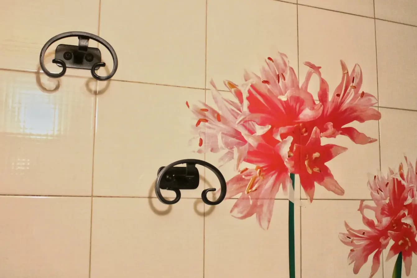 Dettaglio di decoupage in bagno, con dei fiori sul muro