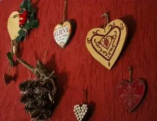 Dettaglio di decorazioni di cuori di legno appesi sul muro della zona giorno