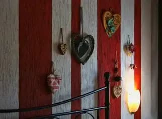 Dettaglio di decorazioni a forma di cuore in legno sul muro della camera da letto