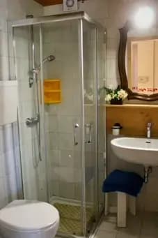 Bagno: la doccia ha vetri in cristallo, ci sono un WC, bidet e un lavandino