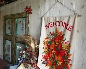 Dettaglio della entrata della reception del Residence, con una porta antica decorata con decoupage e un cartello con scritto 'Welcome'