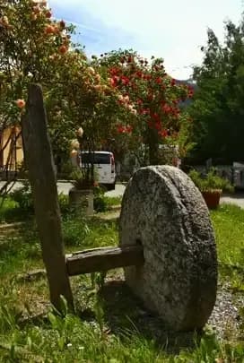 La macina del mulino in pietra nel giardino del Residence