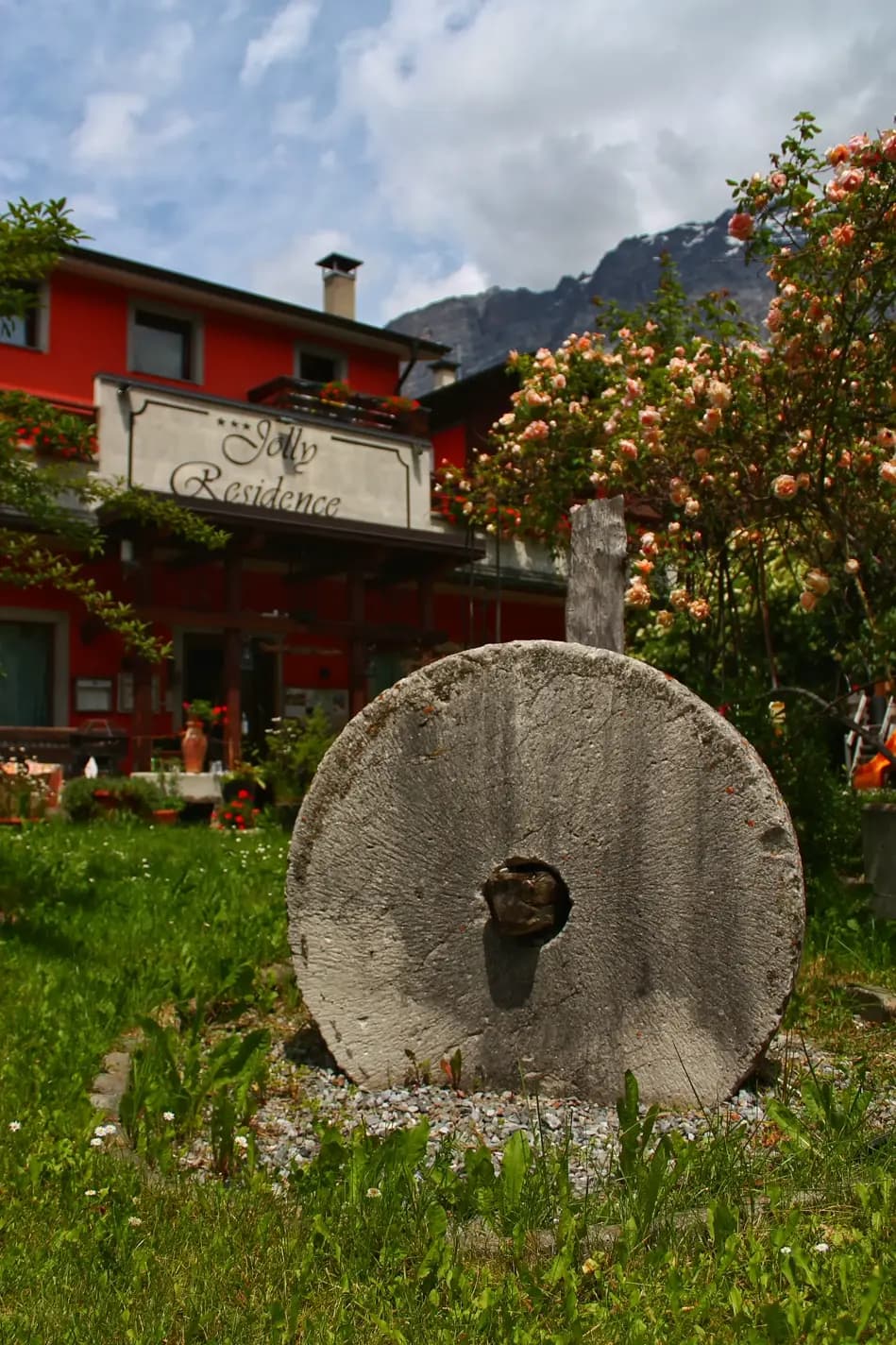 La facciata del Jolly Residence con una macina di un vecchio mulino decorativa in primo piano